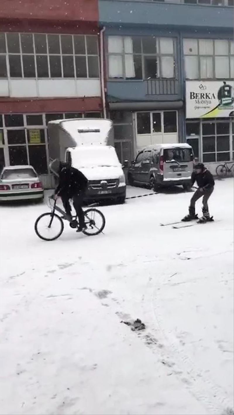 Karla kaplanan yolda kayak takımları ile kayak yaptı